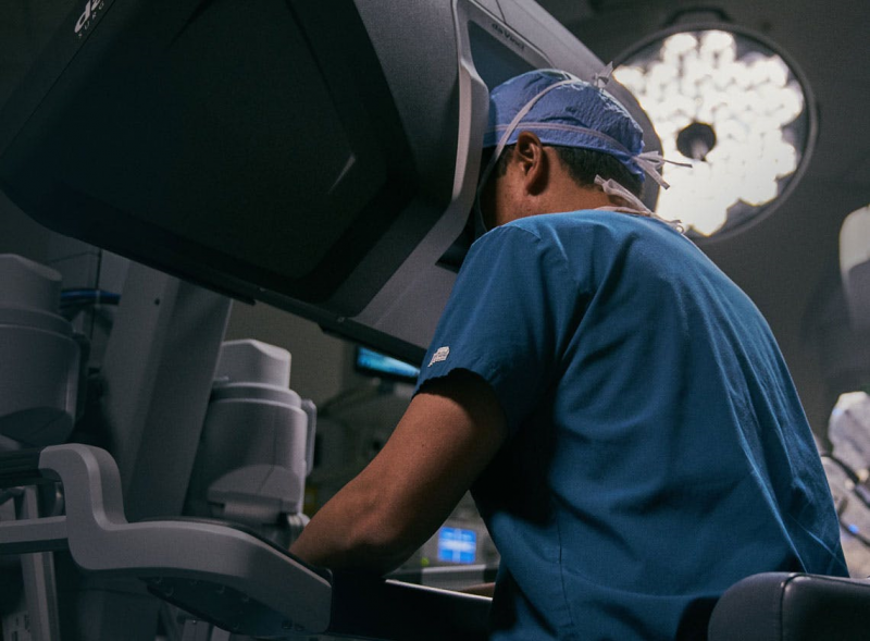 Surgeon looking into da Vinci surgeon console in operating room